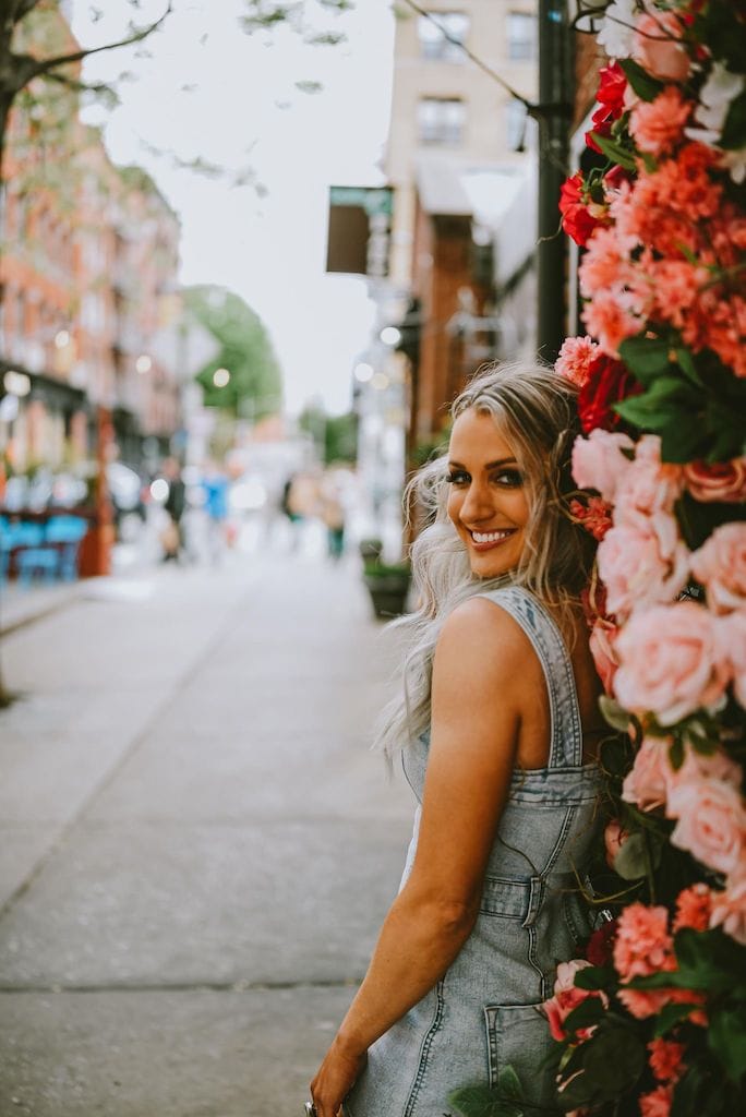 Girl standing outside a building with flowers in NYC