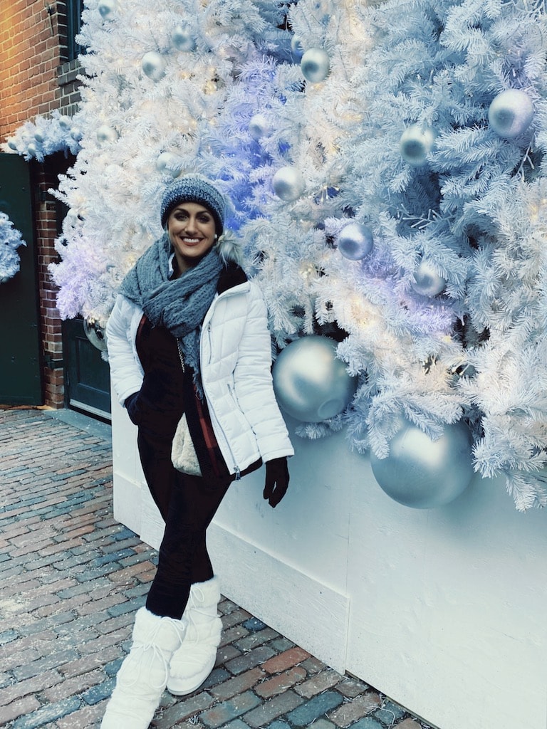 Girl standing outside with Christmas decorations.