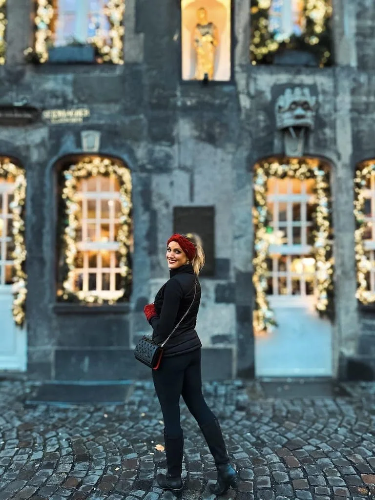 A girl and a building with Christmas lights in Cologne, Germany
