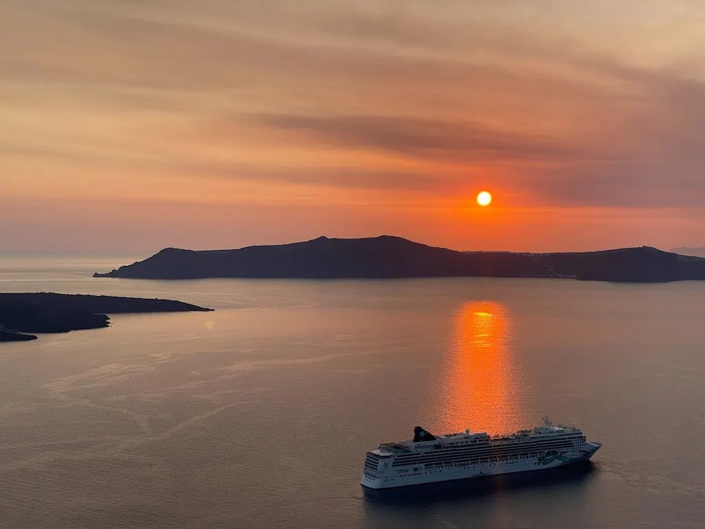 A sunset with a cruise ship in Fira, Santorini, Greece