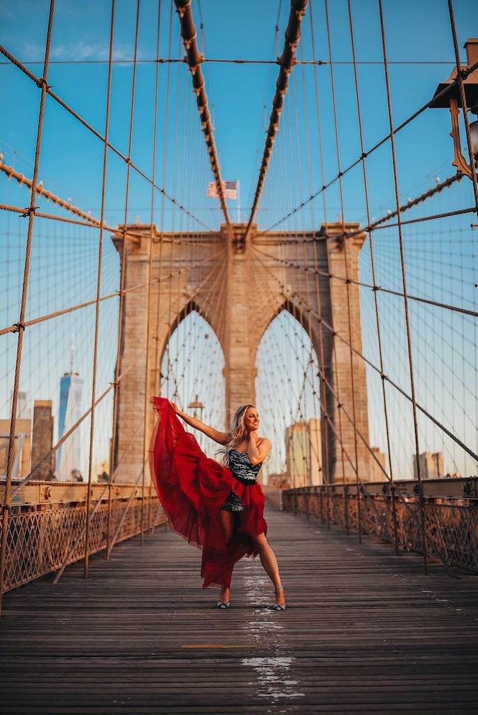 Girl standing on The The Brooklyn Bridge in a dress; NYC