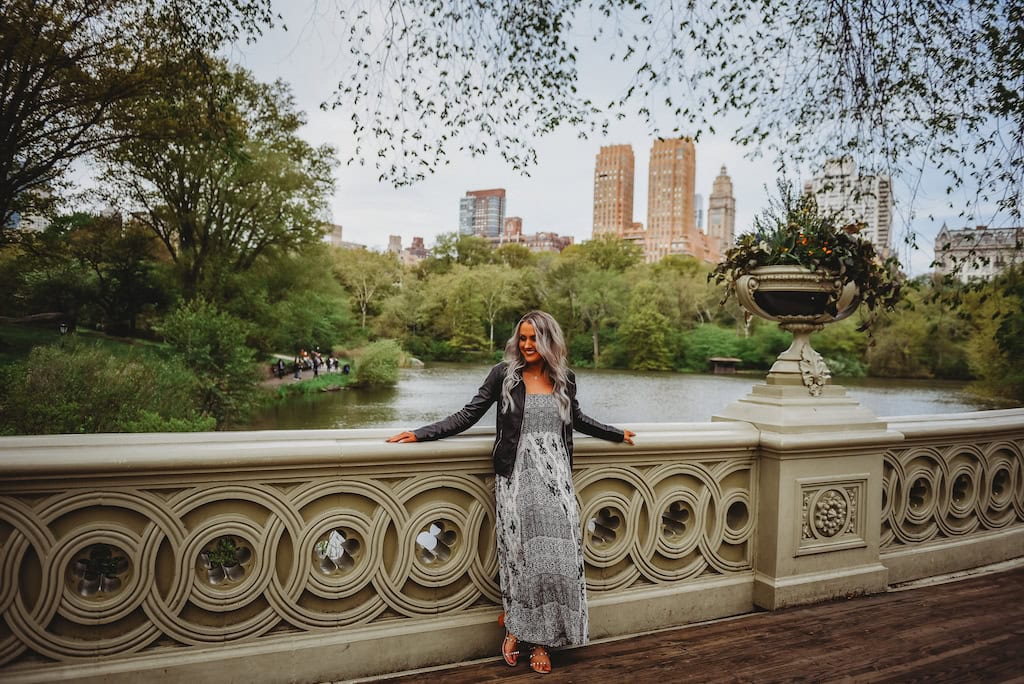 Bow Bridge in Central Park with the Manhattan skyline in the backgrounde