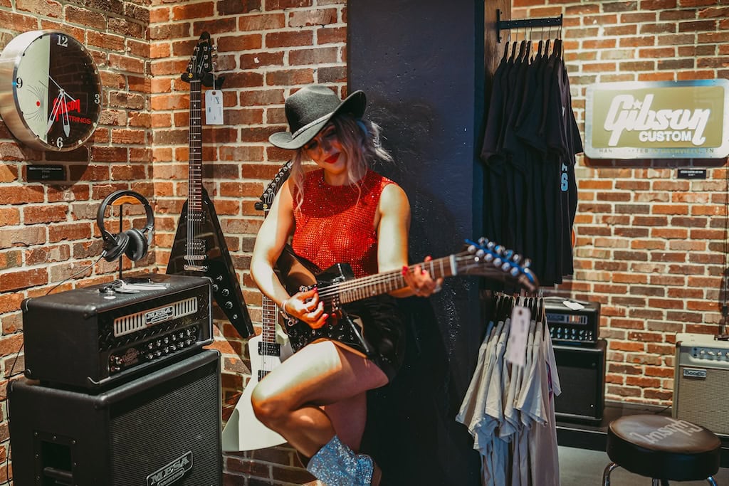 Girl posing near guitars at Gibson Guitar Nashville during a musician photoshoot