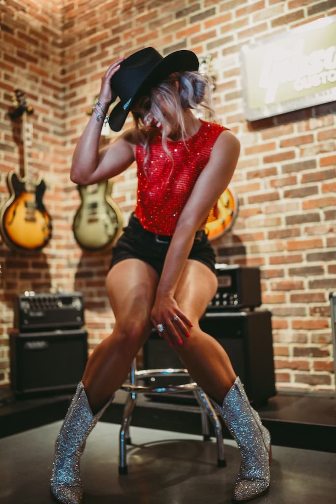 Girl posing near guitars at Gibson Guitar Nashville during a musician photoshoot