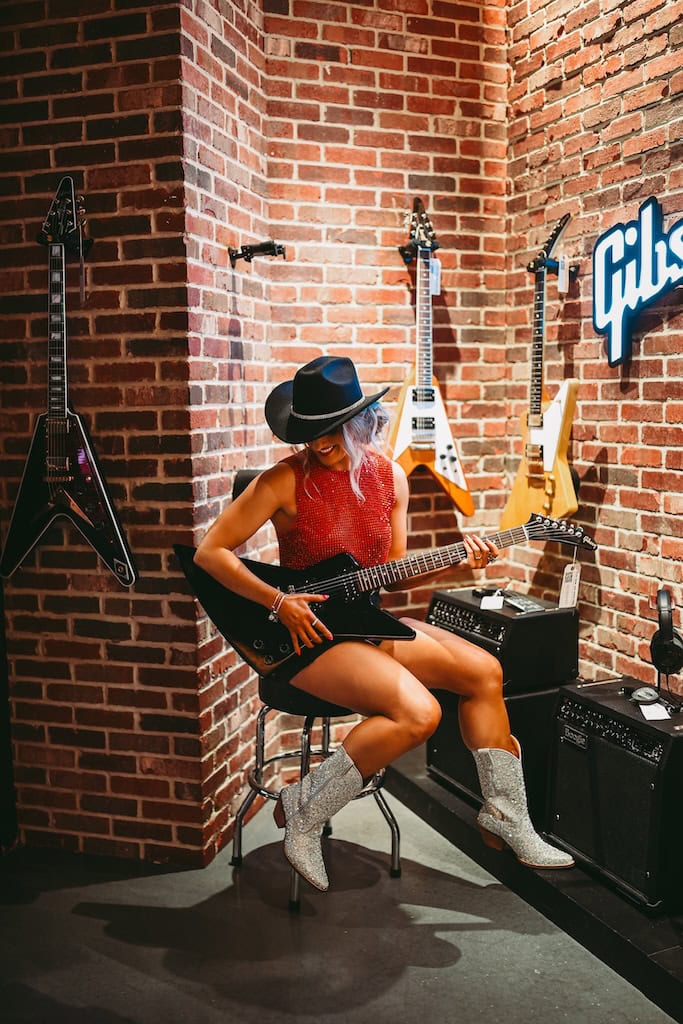 Girl holding a guitar at Gibson Guitar Nashville during a musician photoshoot