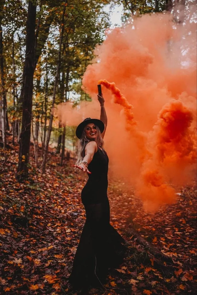 Girl using smoke bombs in photos for a Halloween photoshoot