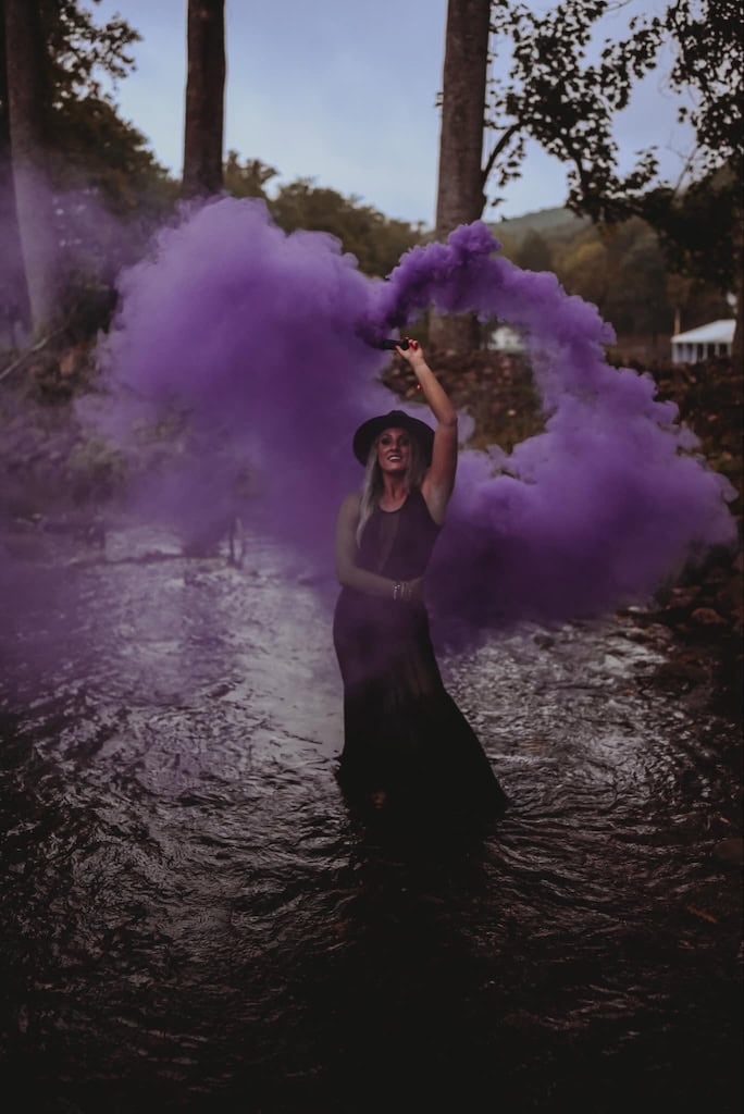 Girl using smoke bombs in photos for a Halloween photoshoot