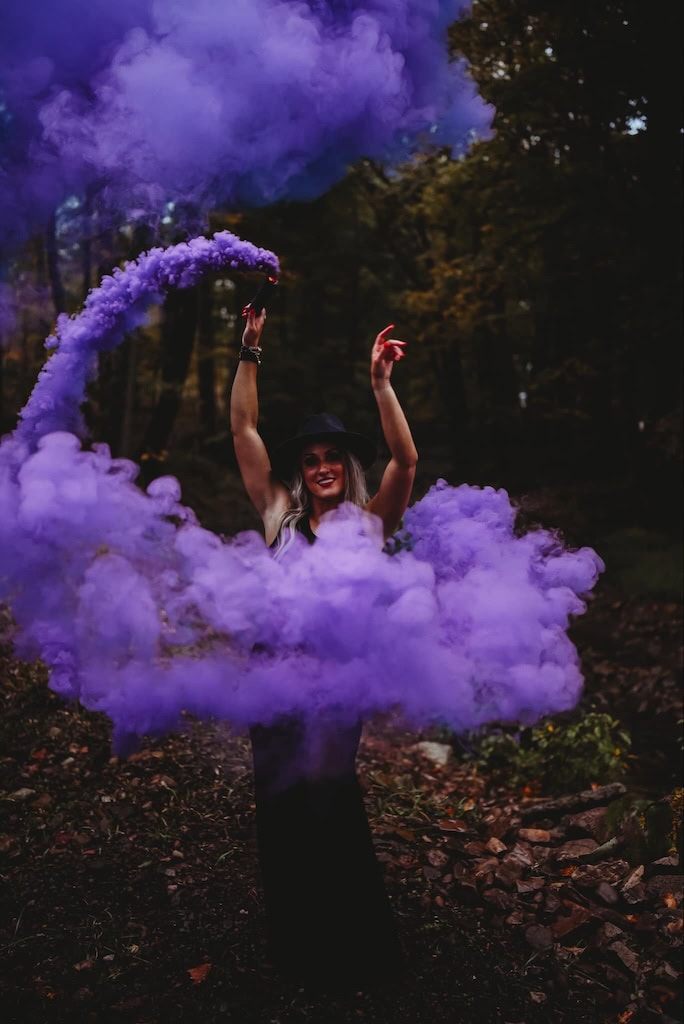 Girl using smoke bombs in photos for a Halloween photoshoot