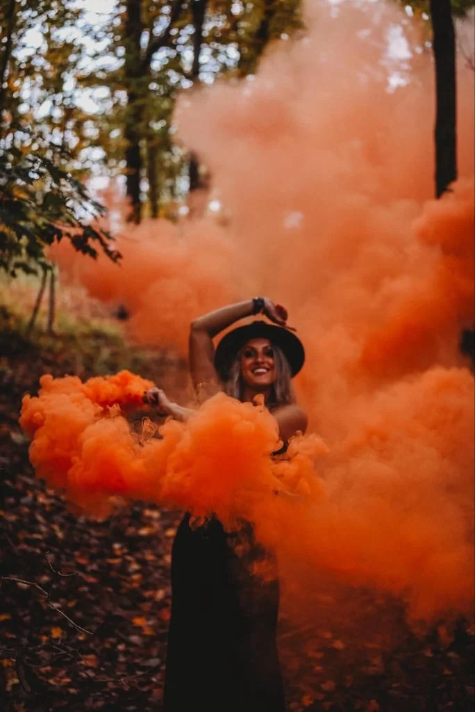 Girl using smoke bombs in photos for a Halloween photoshoot