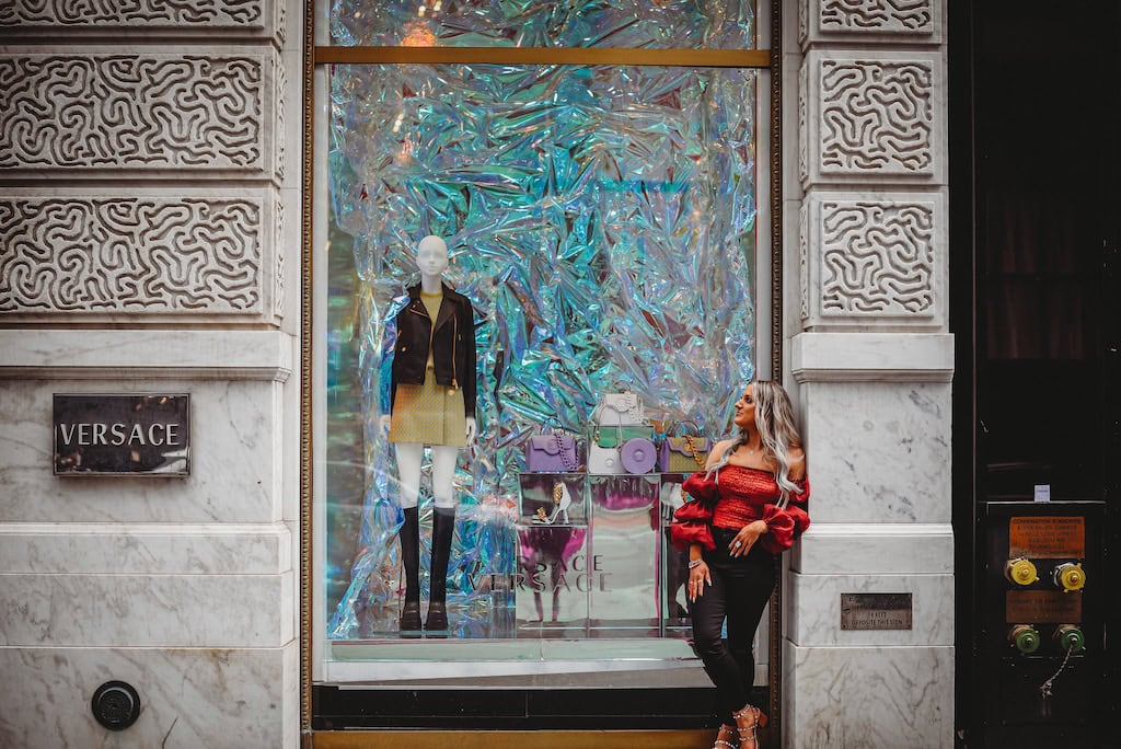 Girl standing outside of the Versace store in NYC