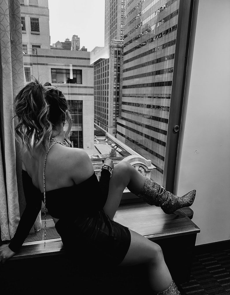 Girl staring out the window in New York City