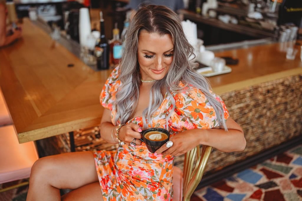 Girl in a flowered dress with a coffee cup