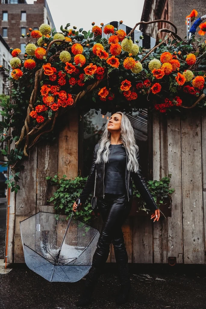 Girl posing in New York City by some flowers.