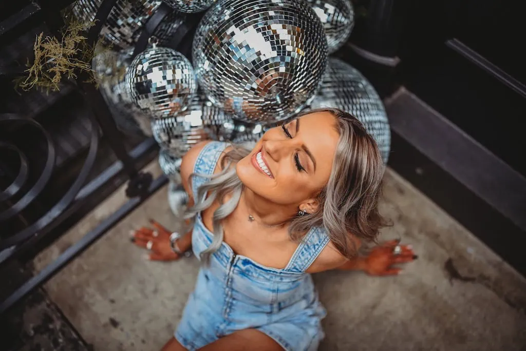 Girl sitting near a cluster of disco balls in New York City
