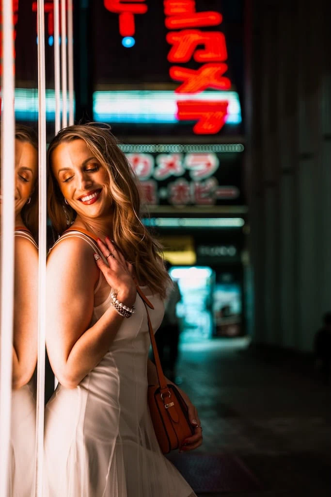 Girl standing beside neon lights in Tokyo, Japan