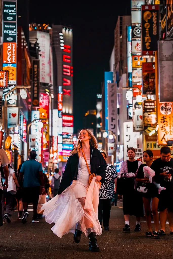 Girl in the middle of downtown Tokyo, Japan surrounded by neon lights